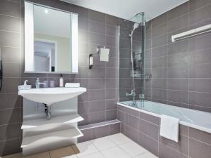 a bathroom with a sink and a bath tub at Aparthotel Adagio Aix-en-Provence Centre in Aix-en-Provence +36 photos