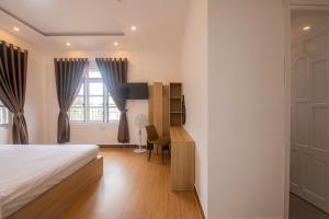 a bedroom with a bed and a desk and a window at Minh Đức Villa in Da Lat