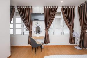 a room with curtains and a chair and a mirror at Minh Đức Villa in Da Lat