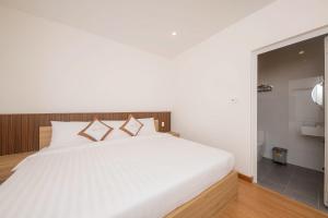 a bedroom with a white bed and a bathroom at Minh Đức Villa in Da Lat