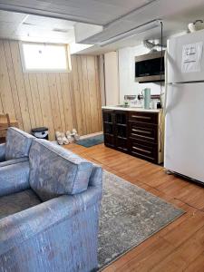 a living room with a couch and a white refrigerator at Beautiful Family-Friendly privet basement in Brossard