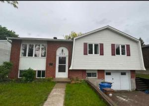 a white and red house with at Beautiful Family-Friendly privet basement in Brossard +2 photos
