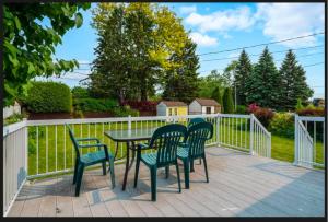 a deck with a table and chairs and a fence at Beautiful Family-Friendly privet basement in Brossard