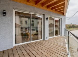 a deck with sliding glass doors on a house at Suite Aracari, clim, balneo, terrasse - Parc des Oiseaux in Villars-les-Dombes