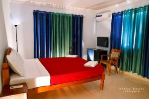 a bedroom with a bed and a chair and curtains at Venice Castle in Alleppey