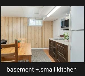 a small kitchen with a table and a refrigerator at Beautiful Family-Friendly privet basement in Brossard