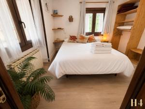 a bedroom with a white bed with towels on it at Hostal Rural Sant Climent - Habitacions i Apartaments in Taüll +69 photos