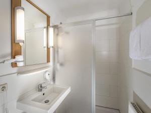 a white bathroom with a sink and a shower at ibis Hotel Eisenach in Eisenach