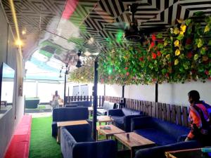 a restaurant with blue couches and flowers hanging from the ceiling at G Spot Hotel in Port Harcourt