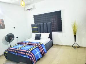 a bedroom with a bed with a black headboard at G Spot Hotel in Port Harcourt