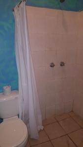 a bathroom with a white shower curtain and a toilet at Hotel hacienda San Jose in La Paz