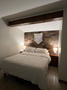 a bedroom with a large bed with a brick wall at Agradable y Acogedora Casa Moderna en Puerto Varas in Puerto Varas