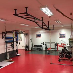 a gym with a red floor and a rack with weights at Mari Kiri Penzion in Bratislava