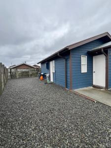 a blue house with a gravel driveway in front of it at Agradable y Acogedora Casa Moderna en Puerto Varas in Puerto Varas