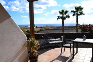 un patio con mesa, sillas y el océano en Apartamento La Finca en Mácher