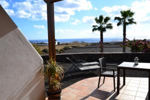 a patio with a table and chairs and the ocean at Apartamento La Finca in Mácher