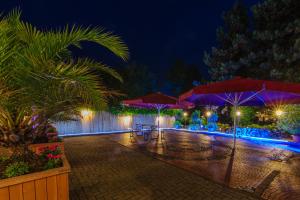 a patio with umbrellas in the rain at night at Akzent Hotel Tietmeyer in Schöppingen