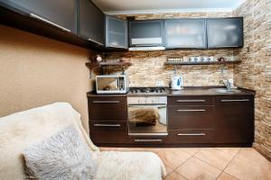 a kitchen with a stove and a microwave at House Na Kurgannoy in Chernihiv