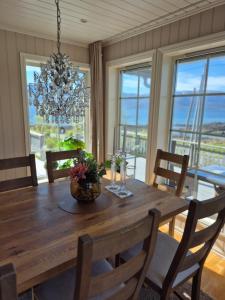 a dining room with a wooden table and a chandelier at Villa Myklebostad in Sand