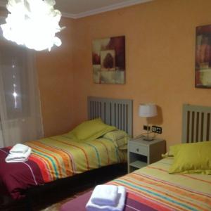 a bedroom with two beds and a lamp at Casa Valfonda in Torres de Barbués