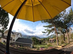 a yellow umbrella in front of a house at Morning Sound in Pyeongchang