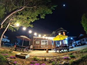 a house with a picnic table and an umbrella at Morning Sound in Pyeongchang