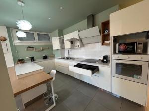 a kitchen with white cabinets and a stove top oven at 4 Star Bologna Train Station - Self Check-In in Bologna