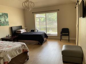 a bedroom with two beds and a window and a chair at Abundant Life in Arlington