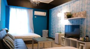 Habitación pequeña con cama y TV. en Summer Kenting B&B, en Nanwan