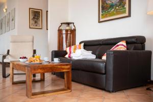 a living room with a black leather couch and a table at Alto Perledo Terrazzo in Perledo
