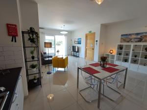 a kitchen and living room with a table and a yellow chair at Lanyard Hitch Court in Marsaxlokk