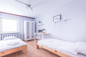 a white room with two beds and a desk at Kujawska Rooms in Lublin