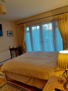 a bedroom with a large bed and large windows at Turnpike Mews in Birr