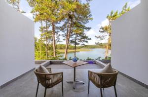 a patio with a table and chairs and a view of a lake at Haven in the Pines in Da Lat