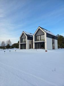 a house in the snow with a yard at Dom nad Zbrzycą MODRY in Swornegacie
