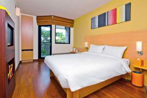 a bedroom with a large white bed and some windows at Ibis Hua Hin in Hua Hin