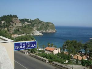 een bord voor een hotel in sulu balilia op een weg bij Hotel Isola Bella in Taormina