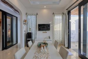 a living room with a white table and chairs at Nalumi Villa in Nusa Penida