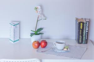 two apples and a cup of coffee on a table with books at Kujawska Rooms in Lublin