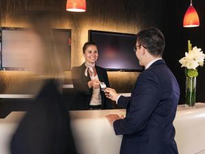 a man and a woman standing in front of a mirror at Mercure Lyon Centre - Gare Part Dieu in Lyon