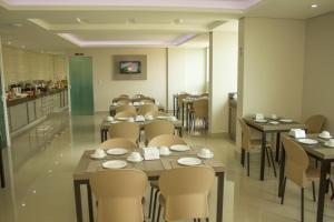a dining room with tables and chairs in a restaurant at Patos Hotel in Patos de Minas