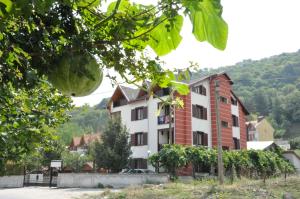 a building with a bunch of trees in front of it at Mekan Ilica Apart Otel in Karacasu