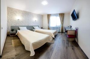 ヨシュカル・オラにあるGostinitsa Tairのベッド2台とテレビが備わるホテルルームです。