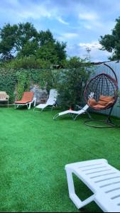 a yard with chairs and a bench on the grass at Волна in Balqash
