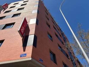 a tall red brick building with a stop sign on it at Ibis Madrid Centro las Ventas in Madrid
