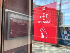 a red pet friendly sign in a store window at Ibis Madrid Centro las Ventas in Madrid