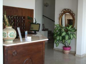 Hotel Isola Bella في تاورمينا: غرفة مع مكتب مع جهاز كمبيوتر ومرآة