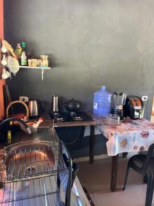 a kitchen with a counter with a stove and a table at Casa Jatobá in Ibicoara