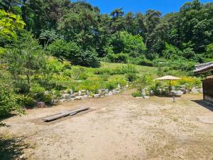 a garden with an umbrella and rocks and trees at Tohyang Traditional House in Bonghwa