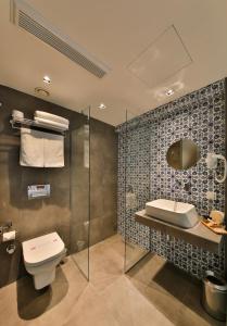 a bathroom with a toilet and a sink and a mirror at Alilass Hotel in Istanbul
